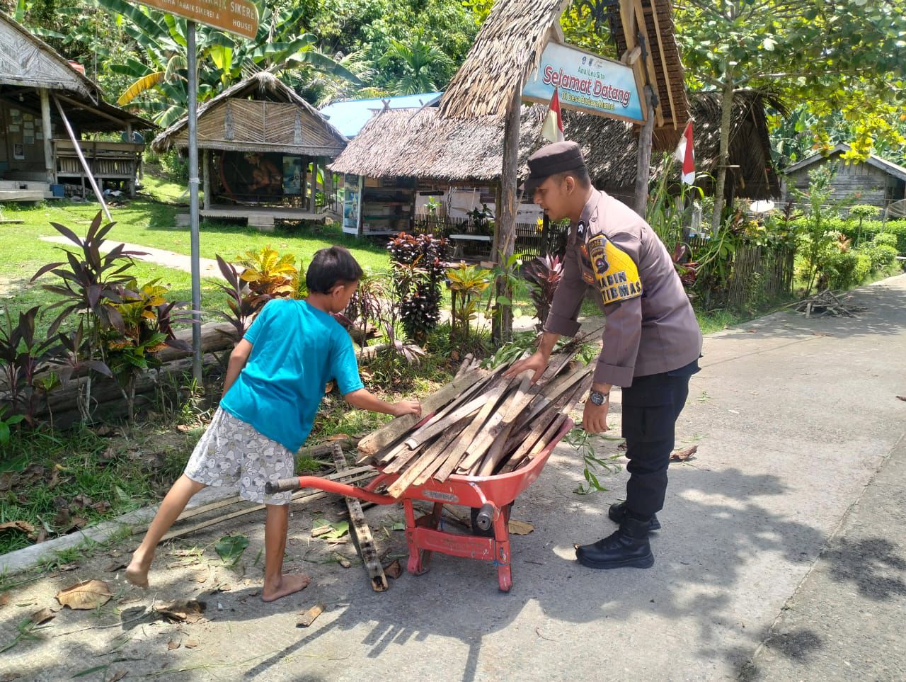 Bhabinkamtibmas Polsek Siberut Bantu Warga Desa Muntei dalam Kegiatan Mengangkat Kayu